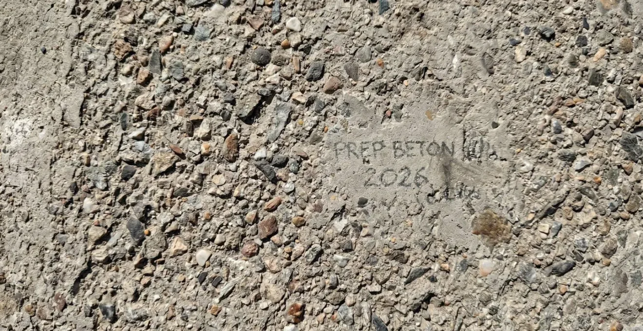 Vue macro rapprochée montrant texture détaillée d'une surface de béton grenaillée avec agrégats exposés et relief prononcé visible sous lumière latérale